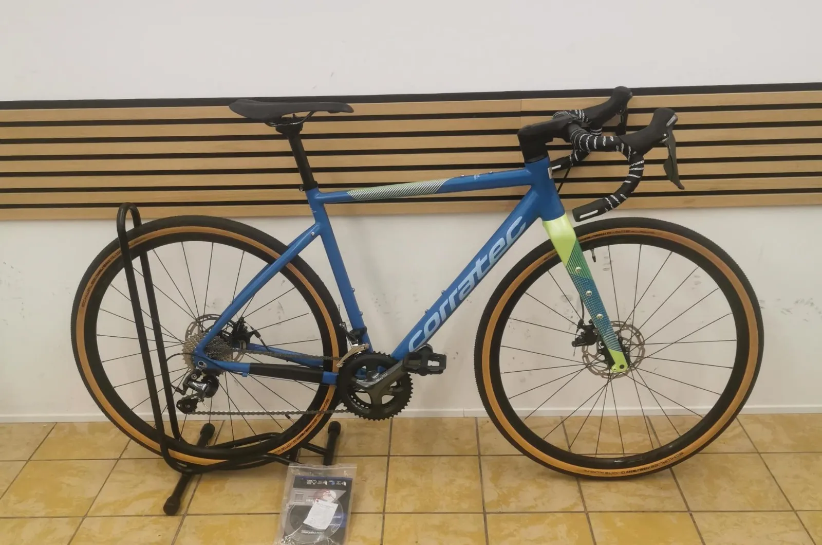 Corratec Gravelbike in Blau mit limefarbener Gabel, Rennlenker und Reifen mit hellen Flanken
