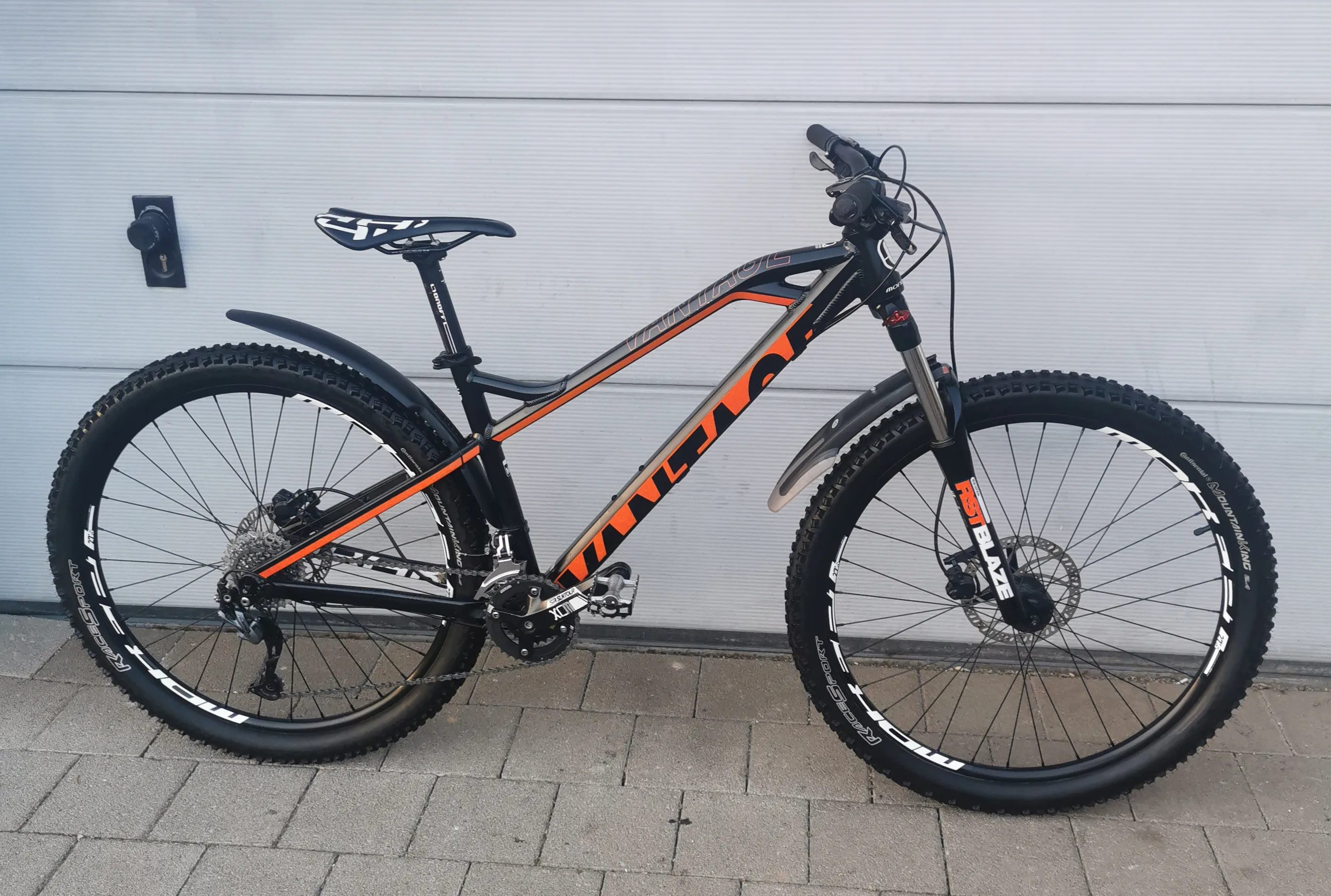 Gebrauchtes Mountainbike in Schwarz-Orange mit Federgabel, Scheibenbremsen und grobstolligen Reifen