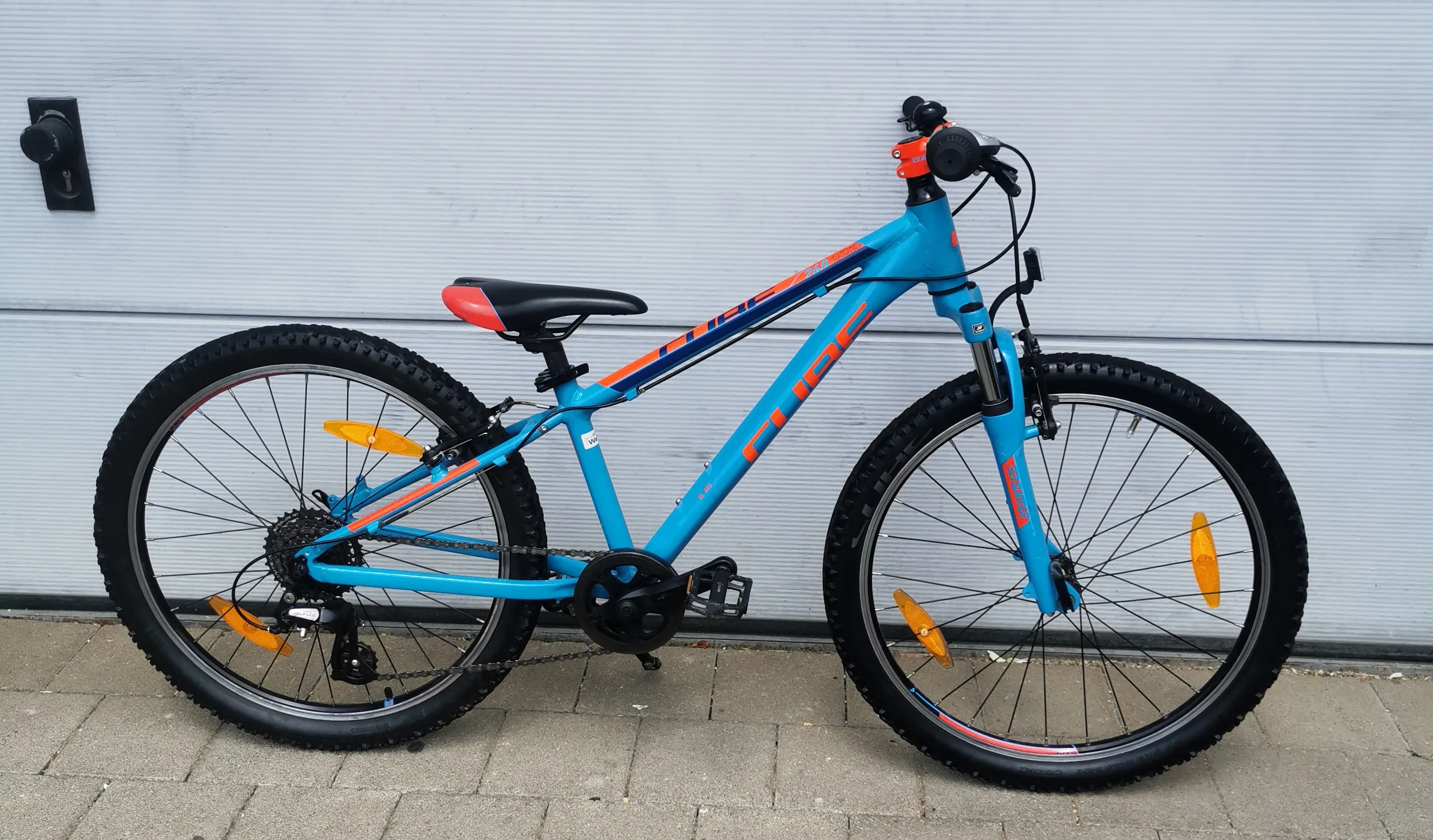 Gebrauchtes Cube Kinder-Mountainbike in Hellblau-Orange mit 24-Zoll-Laufrädern und Federgabel